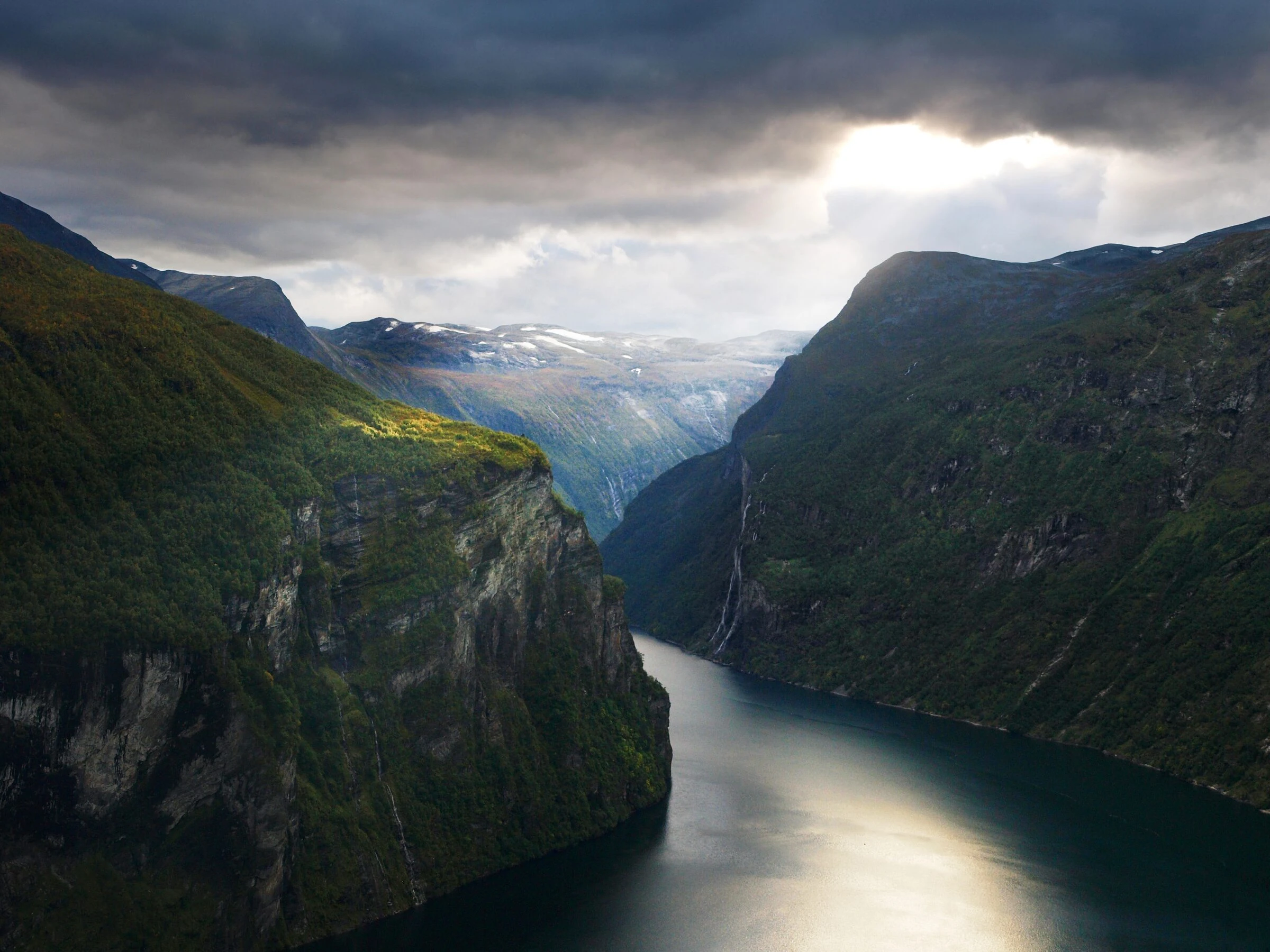 A boat below the cliffs of Geirangerfjord