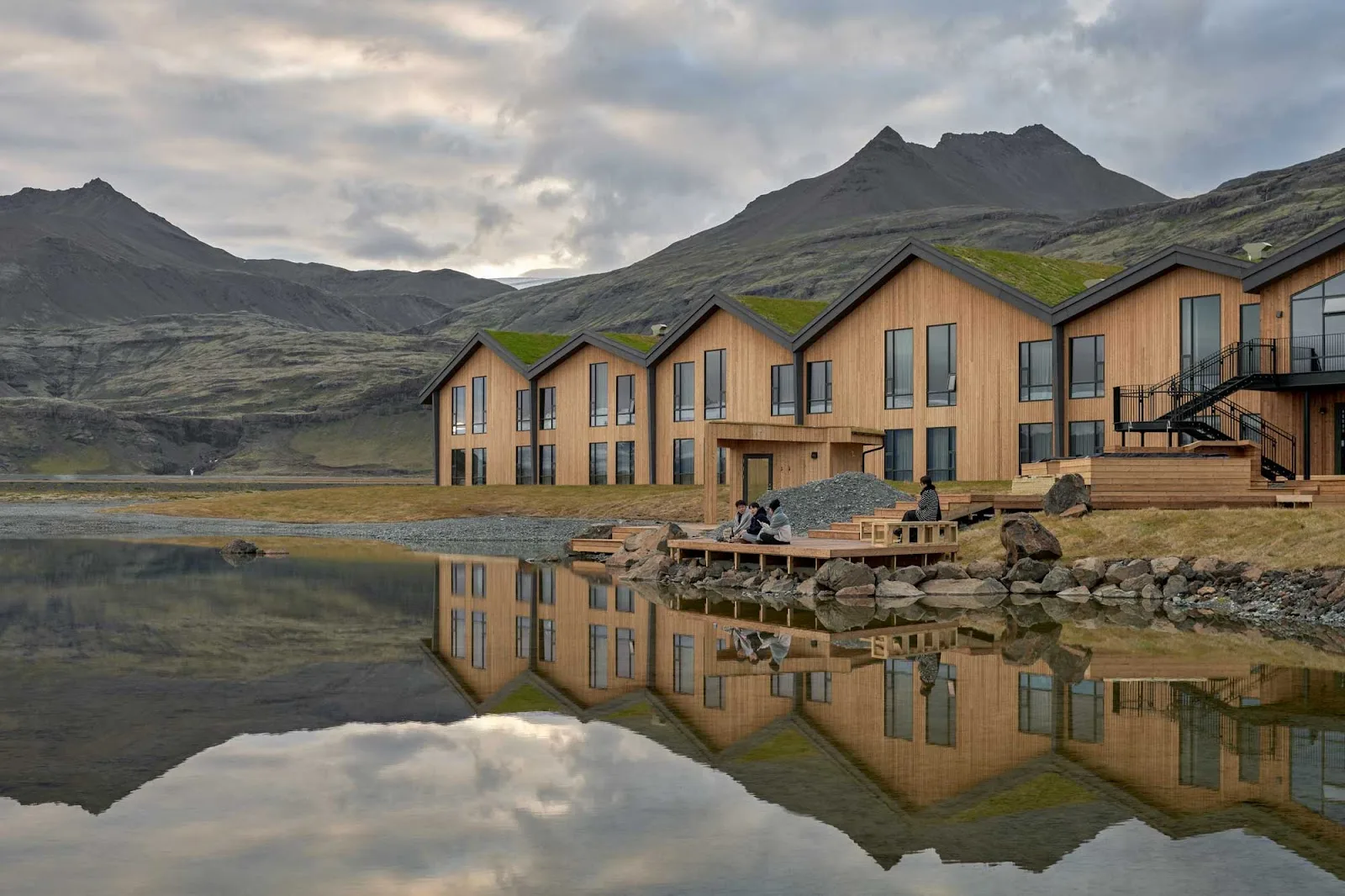 H&oacute;tel J&ouml;kuls&aacute;rl&oacute;n reflected in still water below the mountains